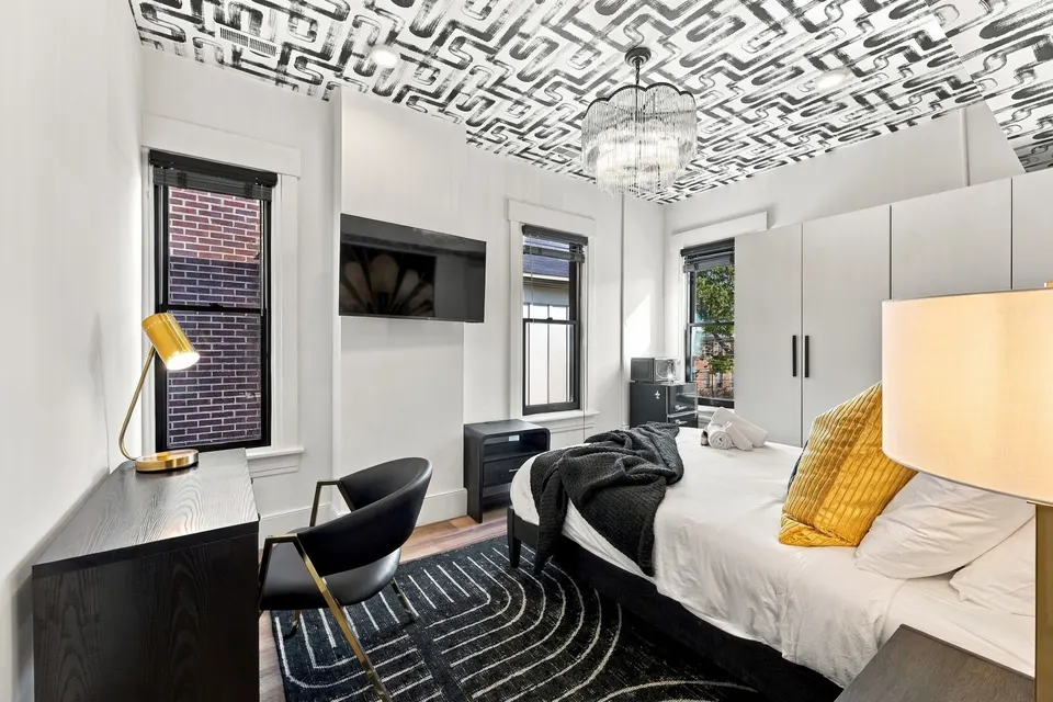 A guest room: Art Deco geometric ceiling, chandelier and gold accents